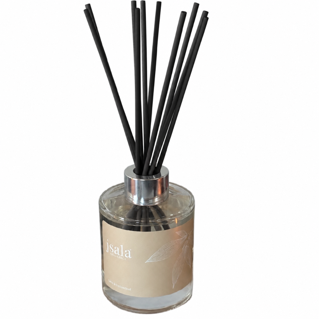 A reed diffuser bottle with a clear glass container, beige label, and multiple black reeds extending upward, shown on a plain white background.