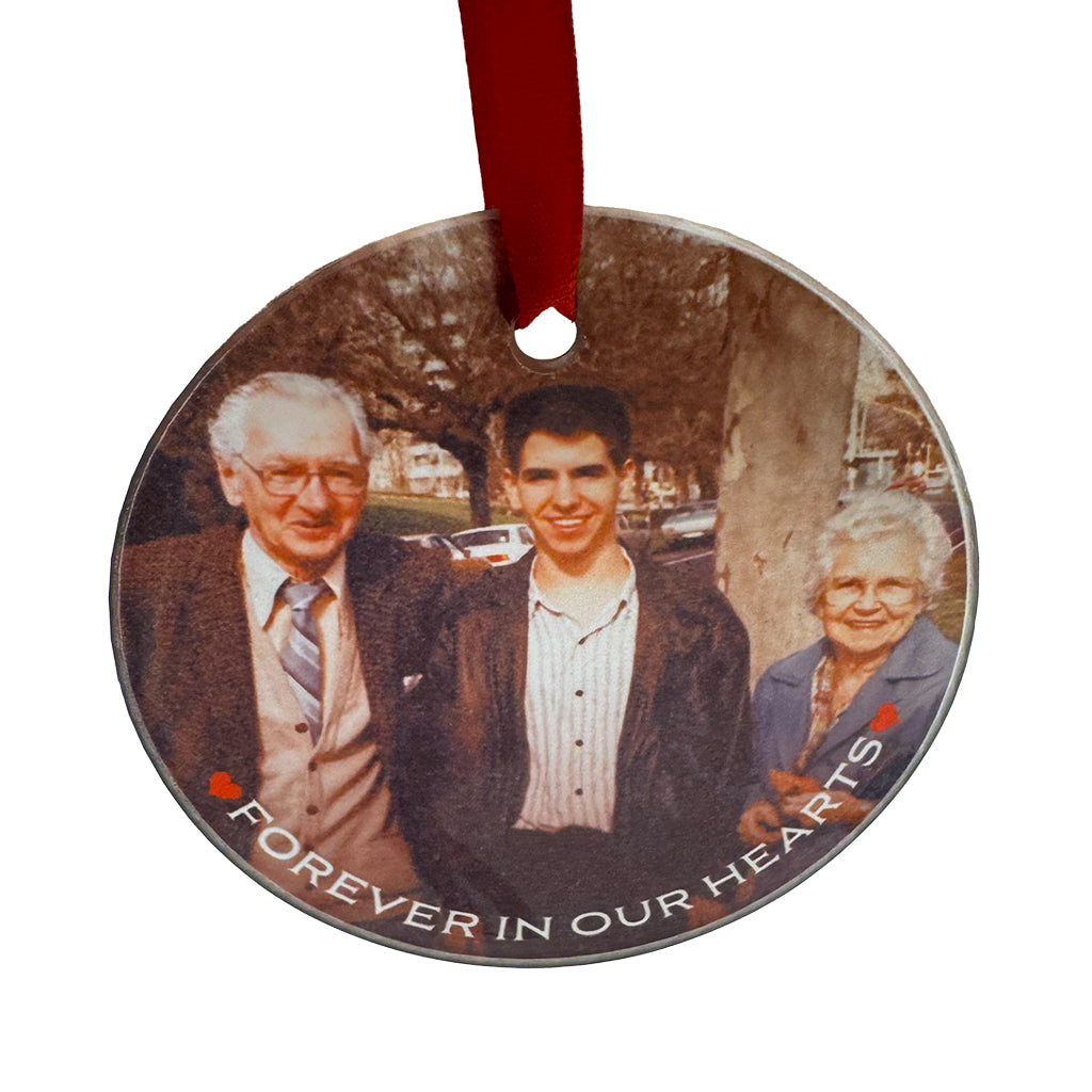 Personalised round glass Christmas ornament with custom photo and message, red ribbon, and linen gift bag.