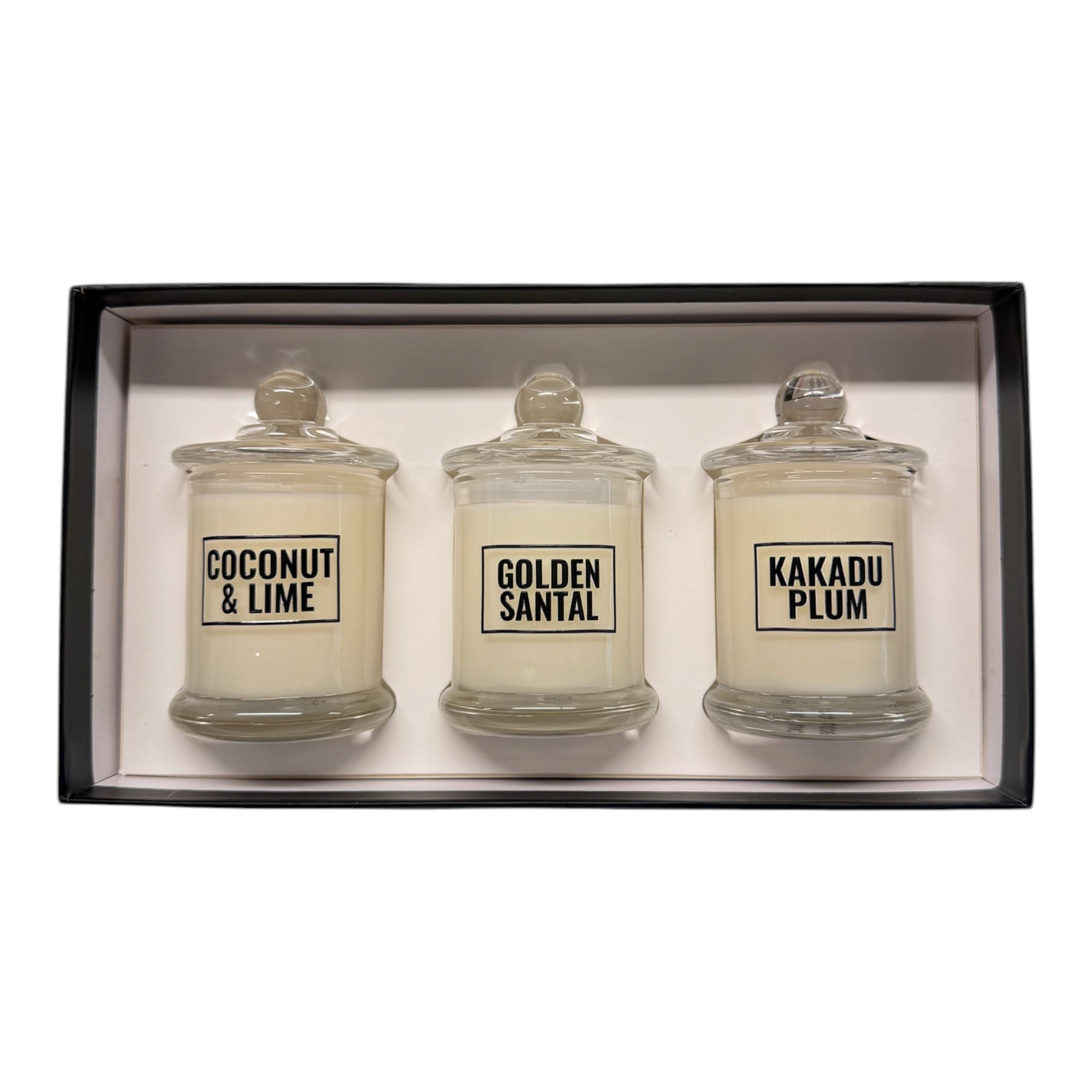 Three glass candles in a box with labels for 'Coconut & Lime', 'Golden Santal', and 'Kakadu Plum'.