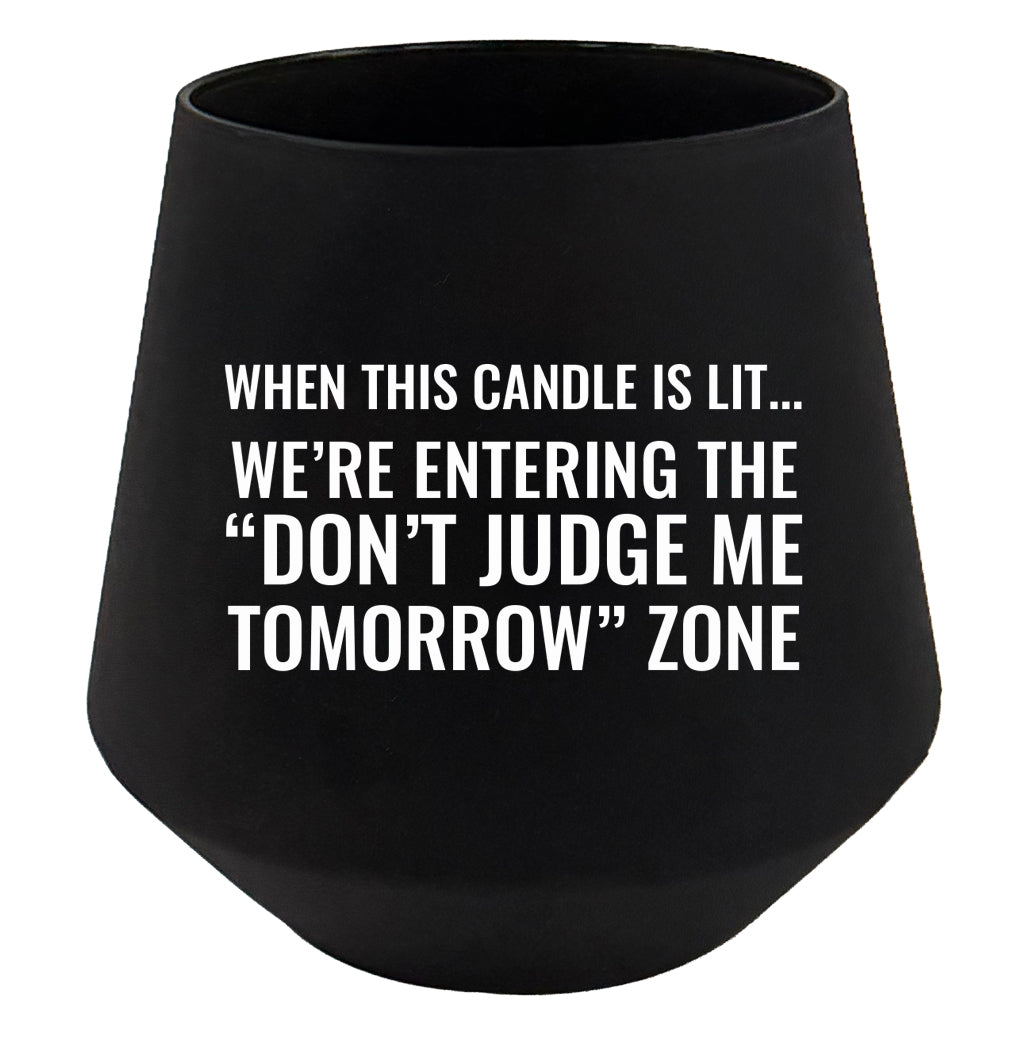 Black candle holder with humorous text on a white background