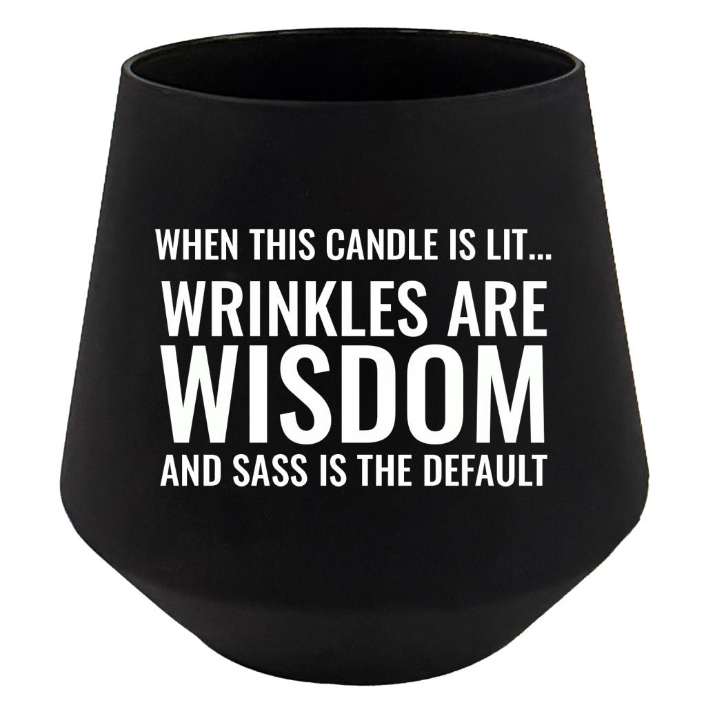 Black candle with white text on a white background