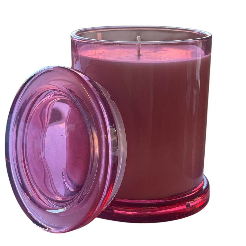 Pink candle with a matching pink lid on a white background