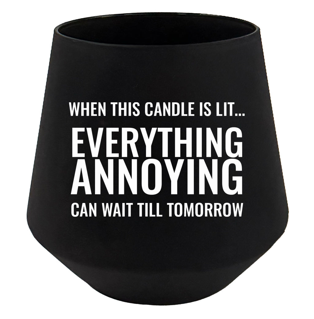 Black candle holder with humorous text on a white background