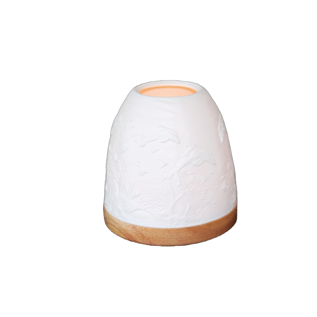 This delicate handmade Dolphin Minikin Lantern with artwork by Melanie Hava is moulded with fine white porcelain, which sits on a round wooden base. When lit with our tea light candles the warmth of the flame glows through the porcelain and it's true beauty comes to life.