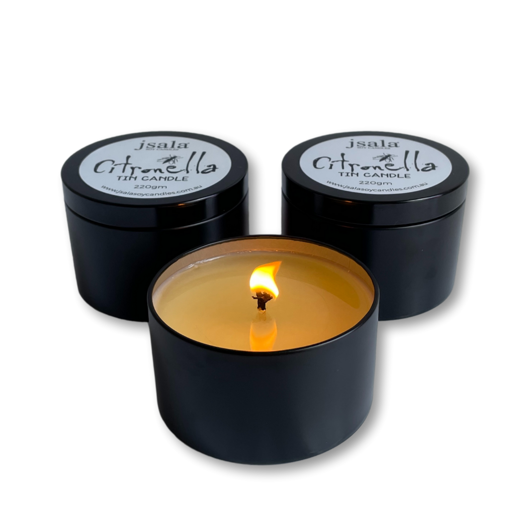 Three Citronella Candle Tins, one is lit.
